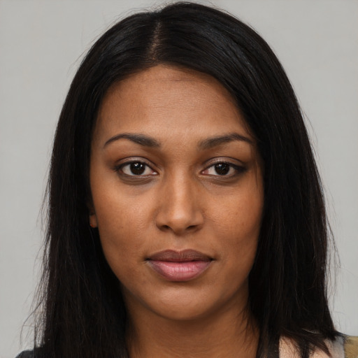 Joyful black young-adult female with long  black hair and brown eyes