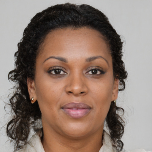 Joyful black adult female with long  brown hair and brown eyes