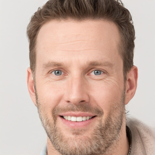 Joyful white adult male with short  brown hair and grey eyes