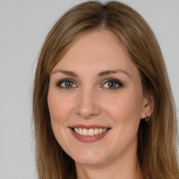 Joyful white young-adult female with long  brown hair and brown eyes