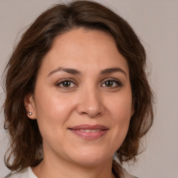 Joyful white adult female with medium  brown hair and brown eyes