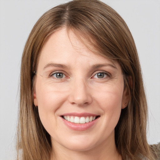 Joyful white young-adult female with long  brown hair and grey eyes