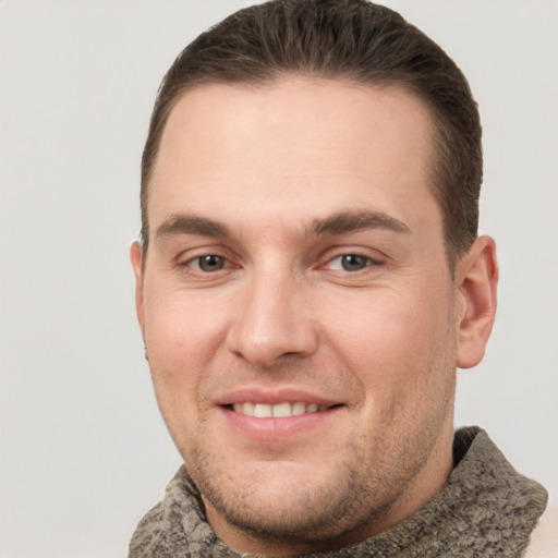 Joyful white young-adult male with short  brown hair and grey eyes