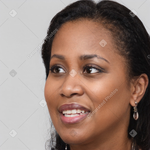 Joyful black young-adult female with long  brown hair and brown eyes