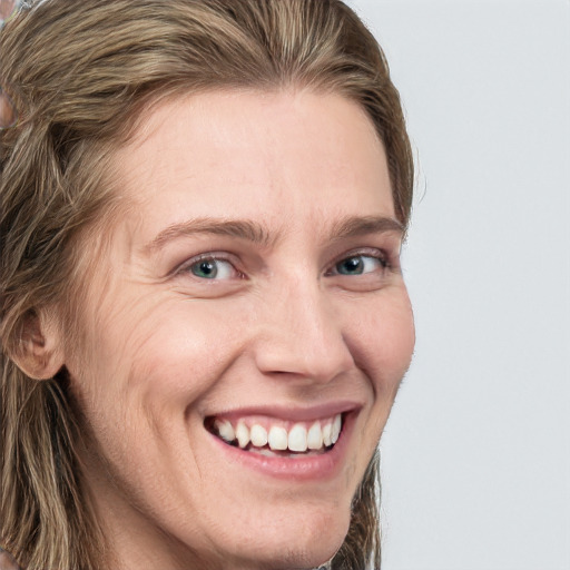 Joyful white adult female with long  brown hair and blue eyes