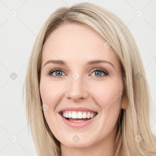 Joyful white young-adult female with long  brown hair and blue eyes