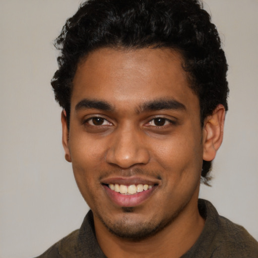 Joyful black young-adult male with short  brown hair and brown eyes
