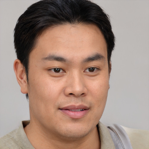 Joyful asian young-adult male with short  brown hair and brown eyes