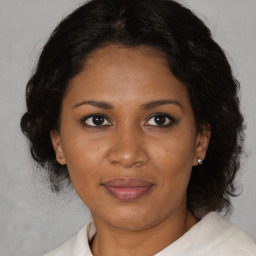 Joyful black adult female with medium  brown hair and brown eyes