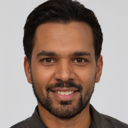 Joyful latino young-adult male with short  black hair and brown eyes