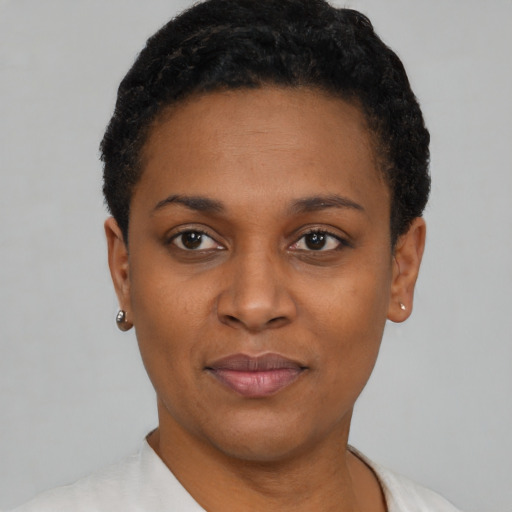 Joyful black young-adult female with short  black hair and brown eyes