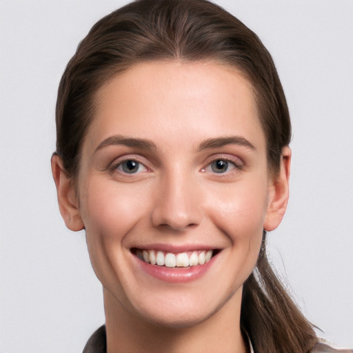 Joyful white young-adult female with long  brown hair and grey eyes