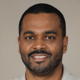 Joyful black young-adult male with short  black hair and brown eyes