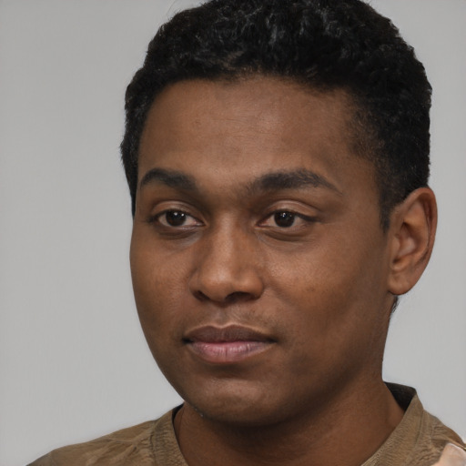 Joyful black young-adult male with short  black hair and brown eyes