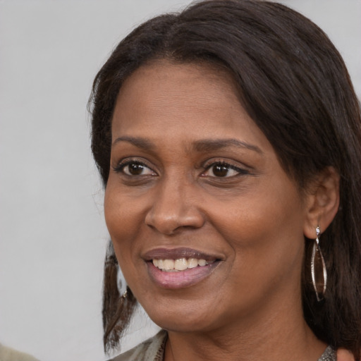 Joyful black adult female with medium  brown hair and brown eyes