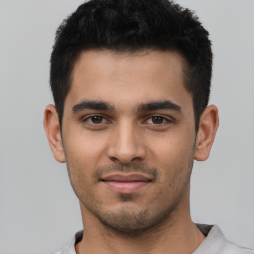 Joyful latino young-adult male with short  black hair and brown eyes