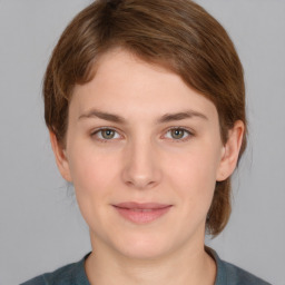 Joyful white young-adult female with medium  brown hair and grey eyes