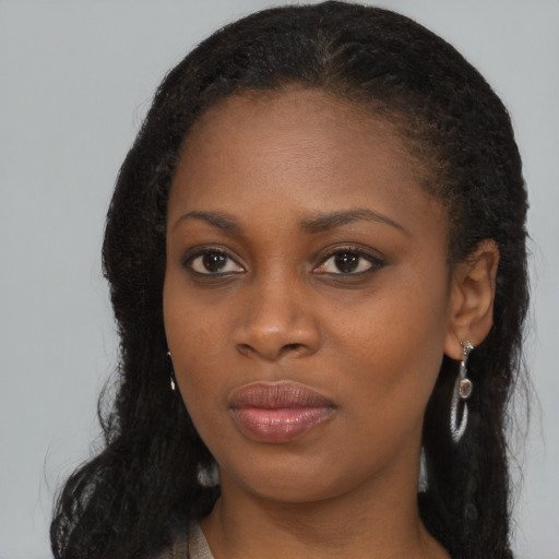 Joyful black young-adult female with long  brown hair and brown eyes
