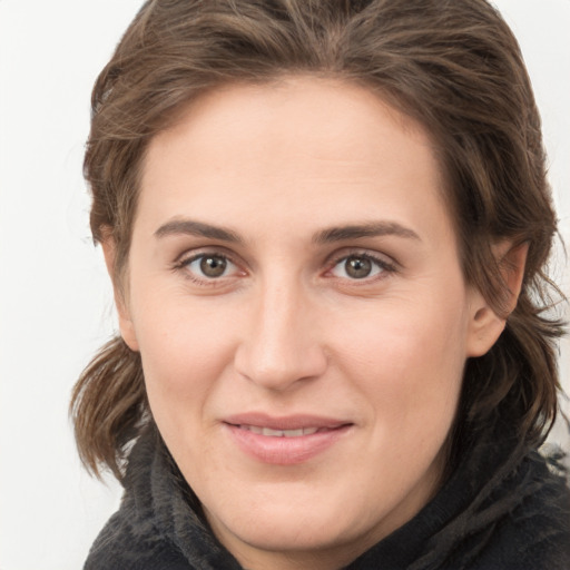 Joyful white young-adult female with medium  brown hair and grey eyes