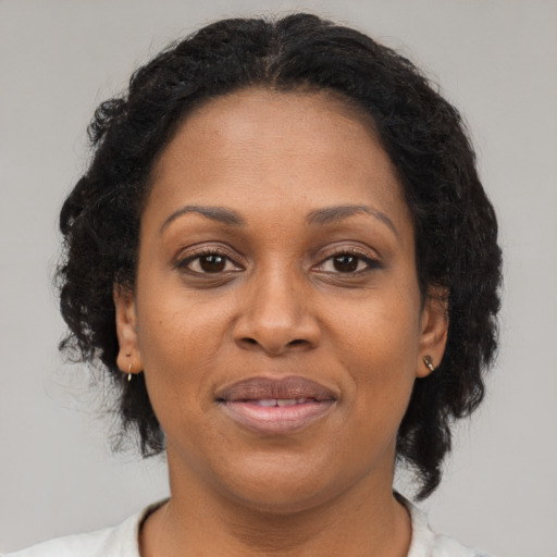 Joyful latino adult female with medium  brown hair and brown eyes