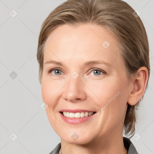 Joyful white young-adult female with medium  brown hair and grey eyes