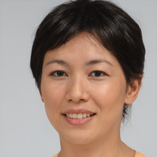 Joyful asian young-adult female with short  brown hair and brown eyes