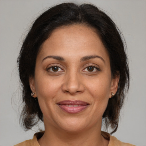 Joyful latino adult female with medium  brown hair and brown eyes