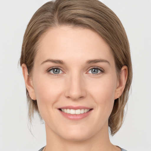 Joyful white young-adult female with medium  brown hair and grey eyes