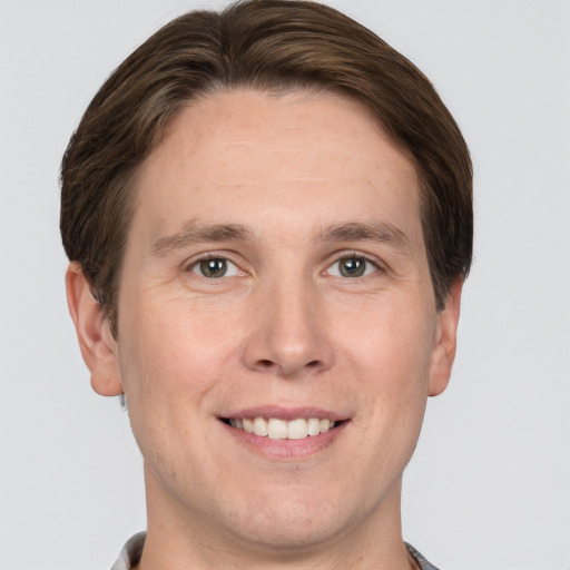 Joyful white adult male with short  brown hair and grey eyes