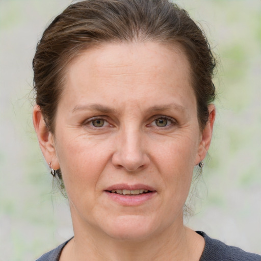 Joyful white adult female with medium  brown hair and grey eyes