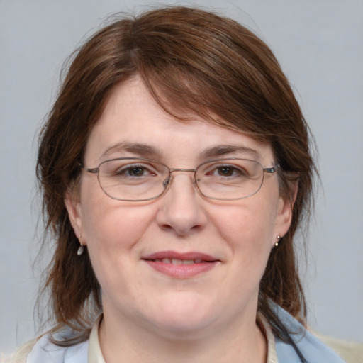 Joyful white adult female with medium  brown hair and blue eyes