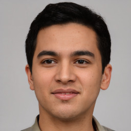 Joyful latino young-adult male with short  black hair and brown eyes