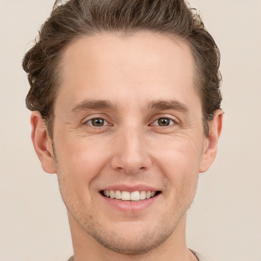 Joyful white young-adult male with short  brown hair and grey eyes