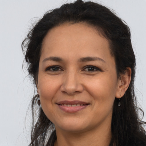 Joyful latino adult female with long  brown hair and brown eyes