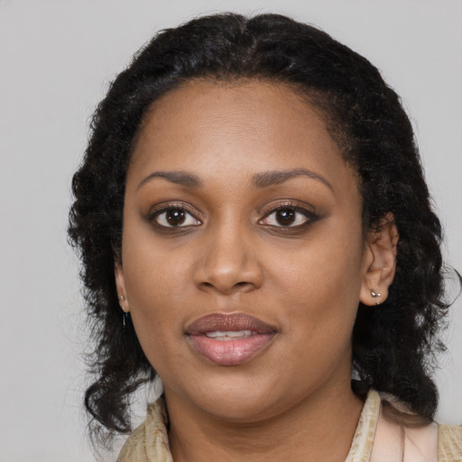 Joyful black young-adult female with long  black hair and brown eyes