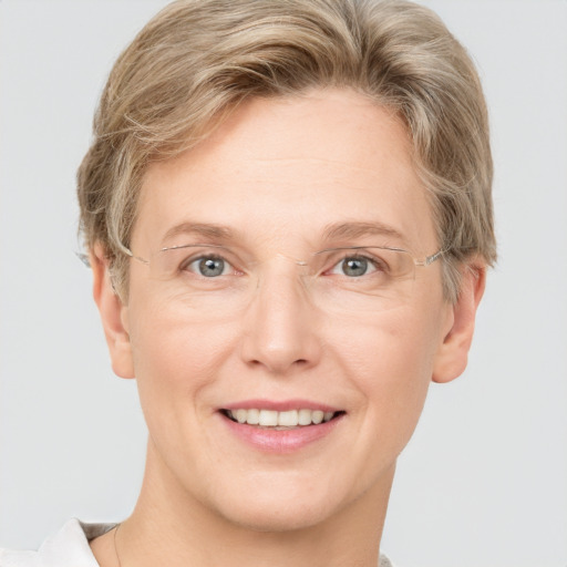 Joyful white adult female with short  blond hair and grey eyes