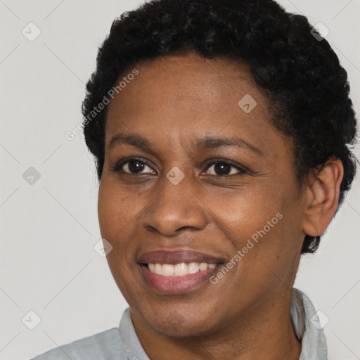 Joyful black young-adult female with short  black hair and brown eyes