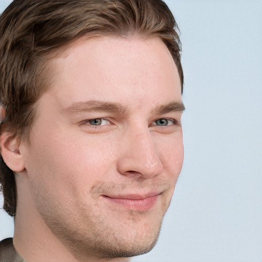 Joyful white young-adult male with short  brown hair and blue eyes