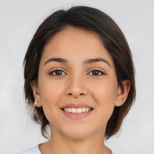 Joyful latino young-adult female with medium  brown hair and brown eyes