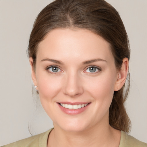 Joyful white young-adult female with medium  brown hair and grey eyes