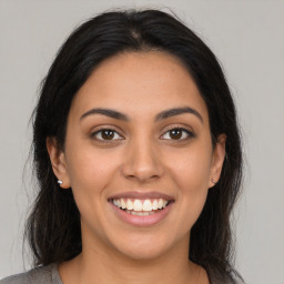 Joyful latino young-adult female with medium  brown hair and brown eyes