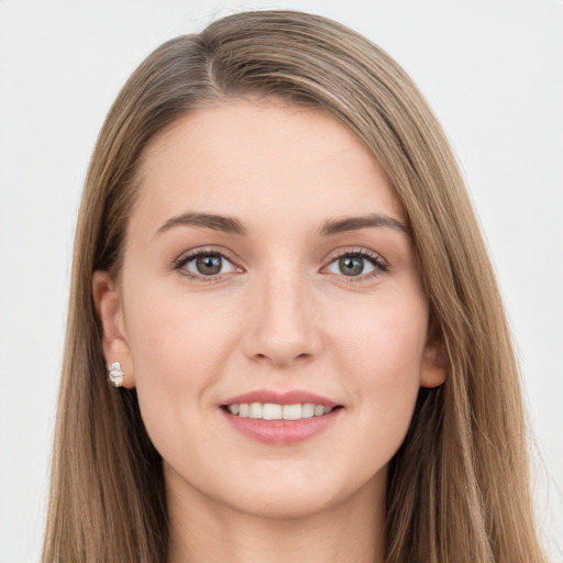 Joyful white young-adult female with long  brown hair and grey eyes