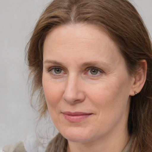 Joyful white adult female with long  brown hair and grey eyes