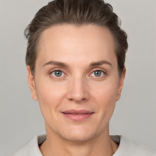 Joyful white young-adult female with short  brown hair and grey eyes