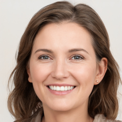 Joyful white young-adult female with long  brown hair and grey eyes