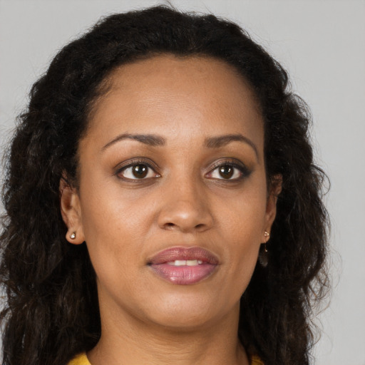 Joyful black young-adult female with long  brown hair and brown eyes