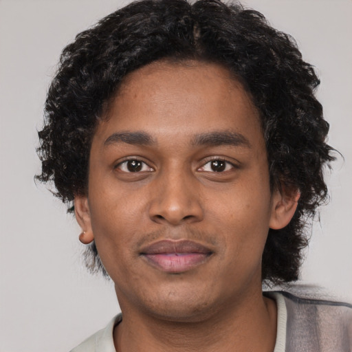 Joyful black young-adult male with short  black hair and brown eyes