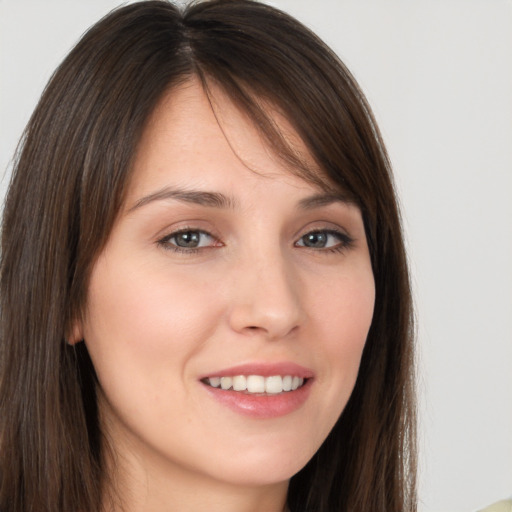 Joyful white young-adult female with long  brown hair and brown eyes