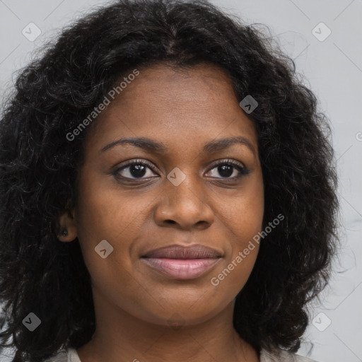 Joyful black young-adult female with long  brown hair and brown eyes