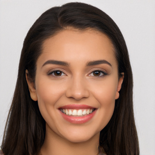 Joyful latino young-adult female with long  brown hair and brown eyes